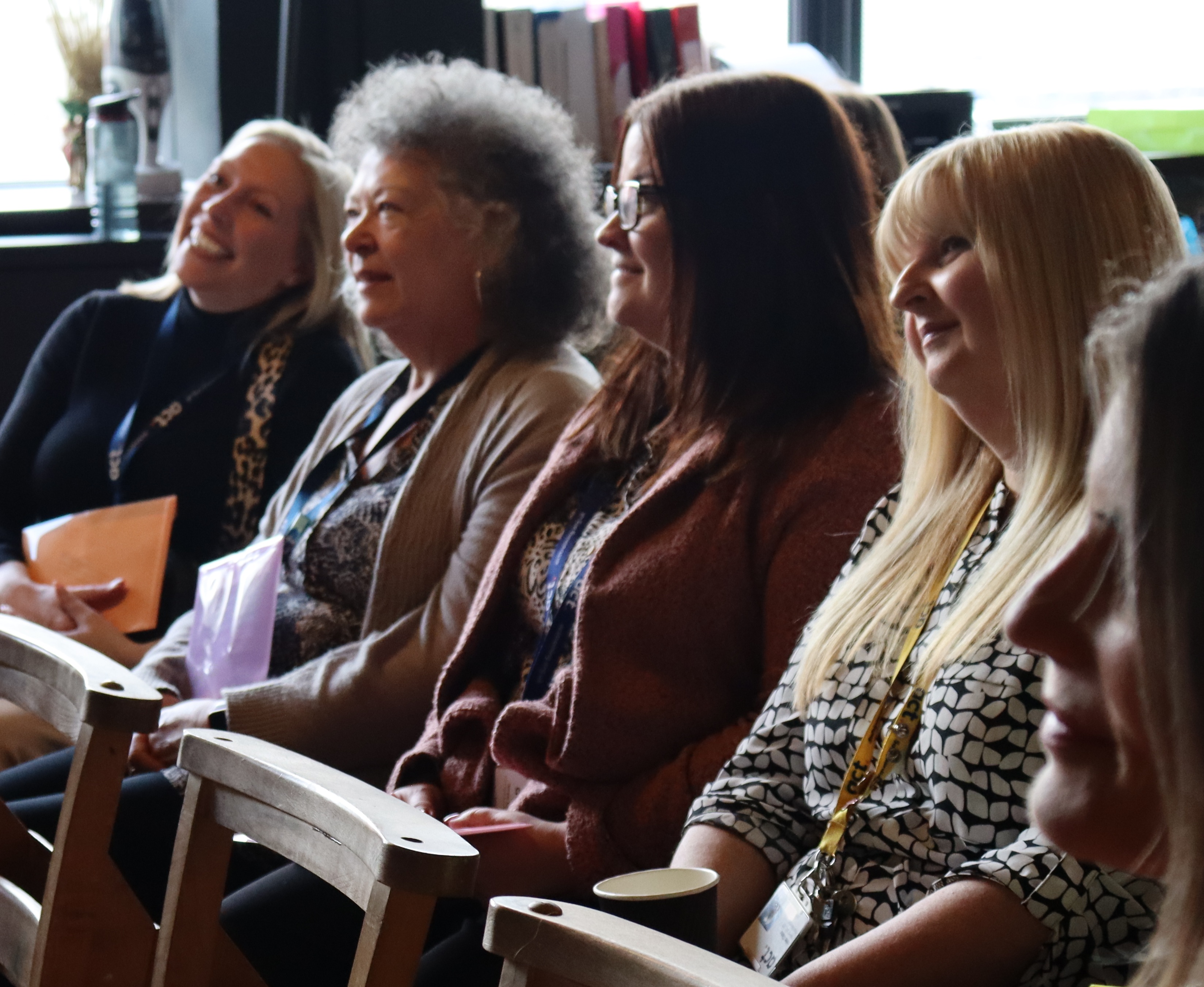 staff yn eistedd yn cyfarfod